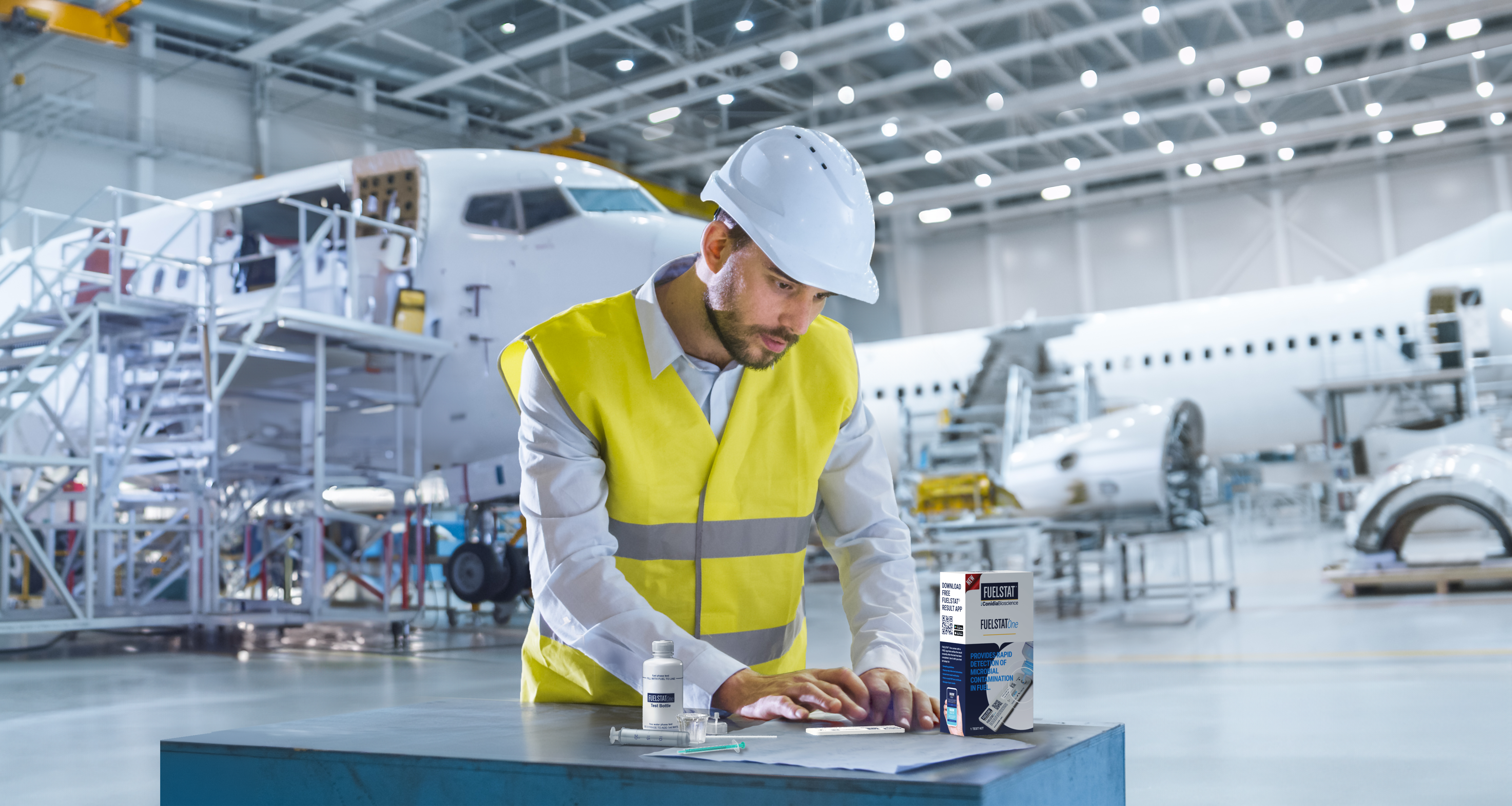 Fuelstat One fuel testing kit with components displayed and a technician performing a test in an aircraft hangar.